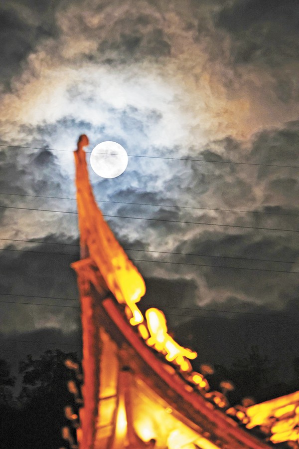 9月29日夜晚,彭水县蚩尤九黎城,夜空中的“超级月亮”与传统建筑屋檐相映成画。特约摄影 赵勇/视觉重庆