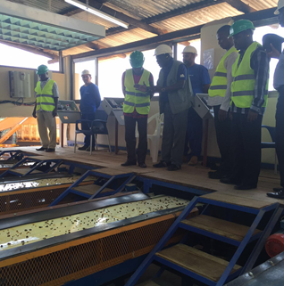 矿区负责人Mousis为楠普拉省领导讲解宝石分拣流程、宝石出产种类和产量，图为经高射水枪冲洗后留下掺杂原石的石砾，分配到传送带，由女工手工分拣